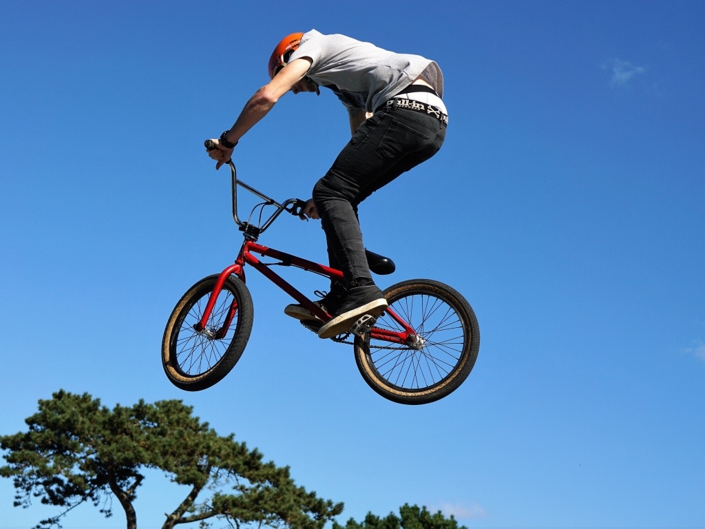 Мужчина делает прыжок на велосипеде на фоне неба
