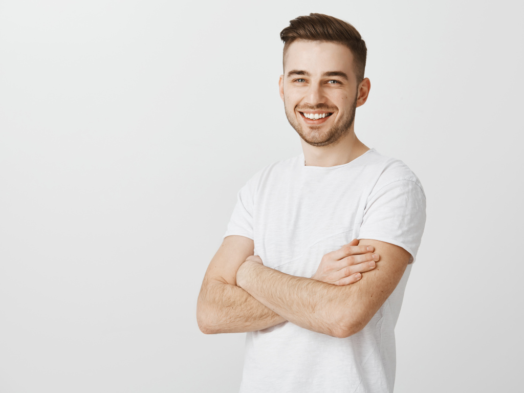 Улыбающийся молодой человек с белой футболке