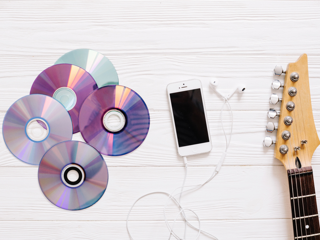 Диски с телефоном и гитарой на белом фоне