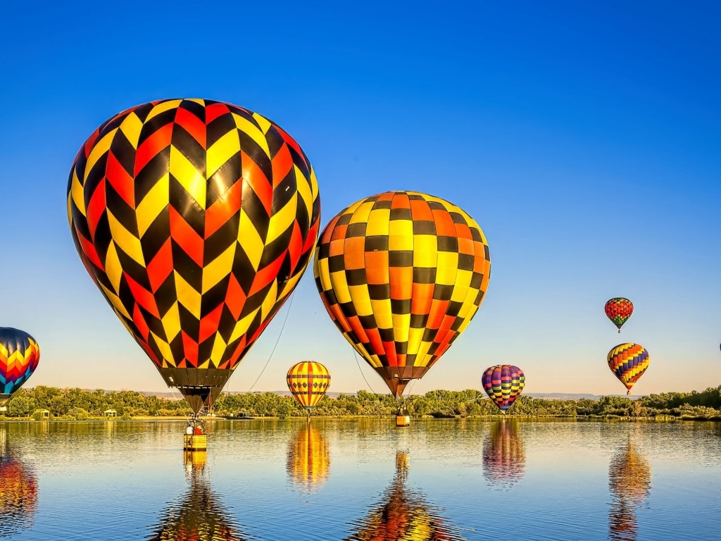 Большие воздушные шары над водой на фоне голубого неба