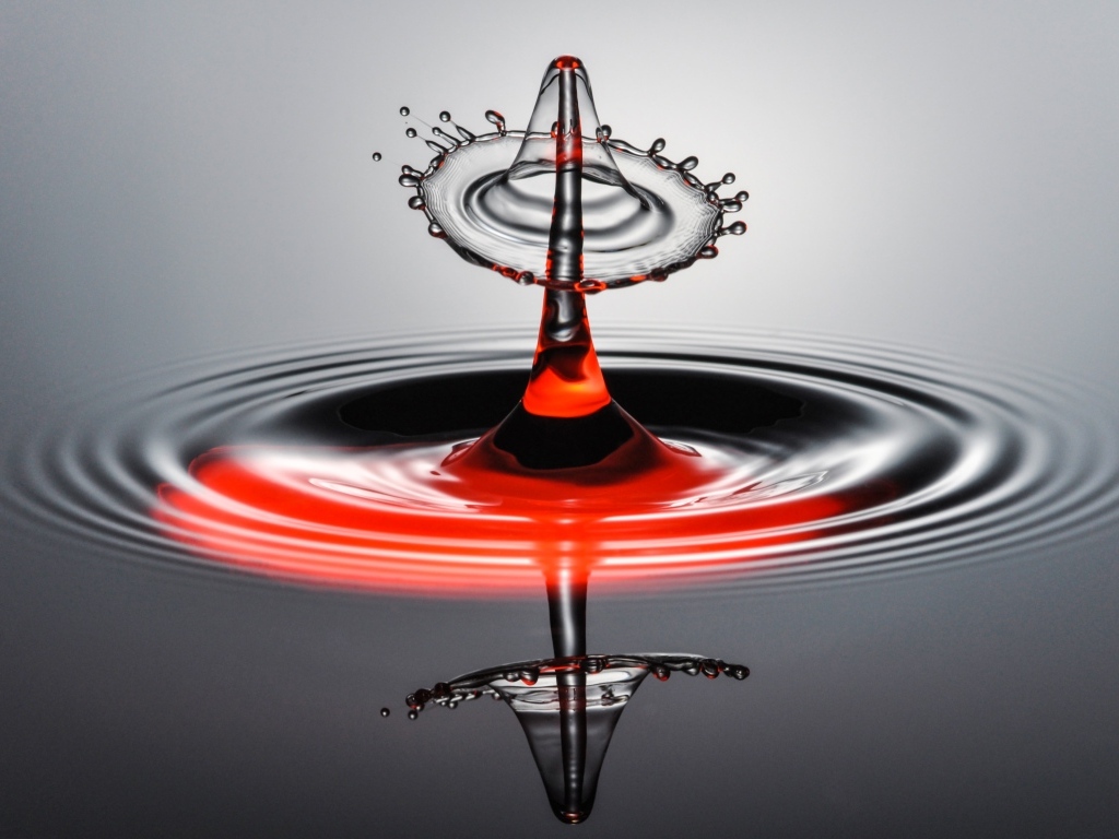 Брызги от капли воды на серой поверхности