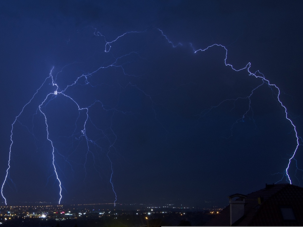Белая яркая молния в небе над городом