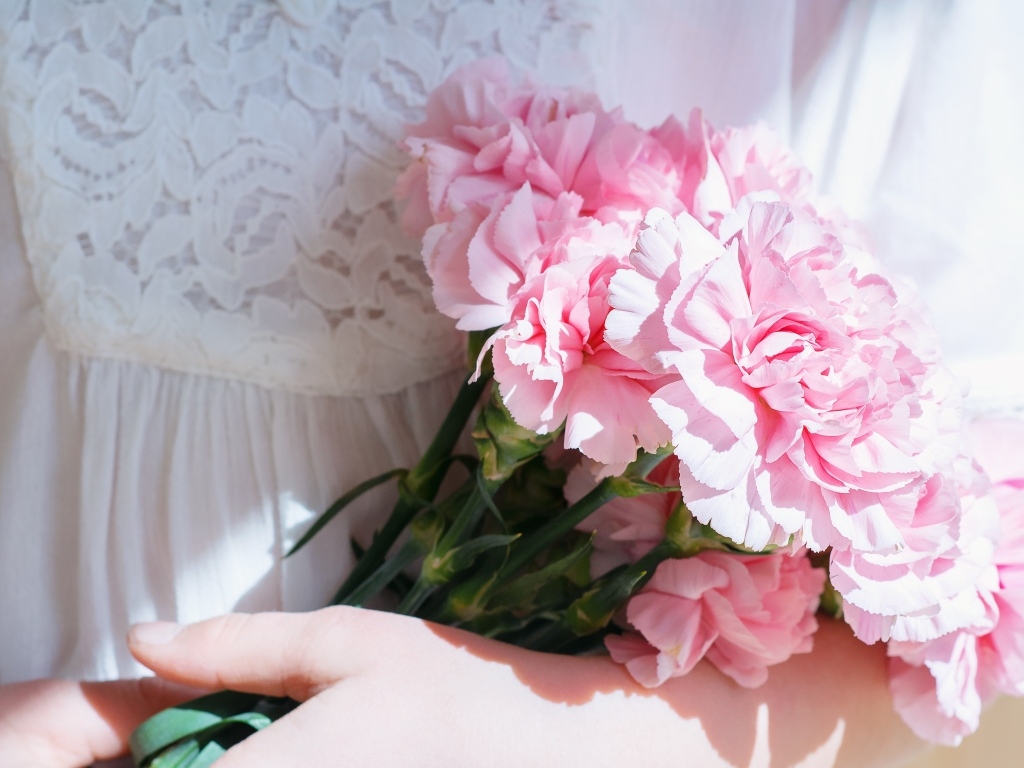 Розовые гвоздики в руках у невесты