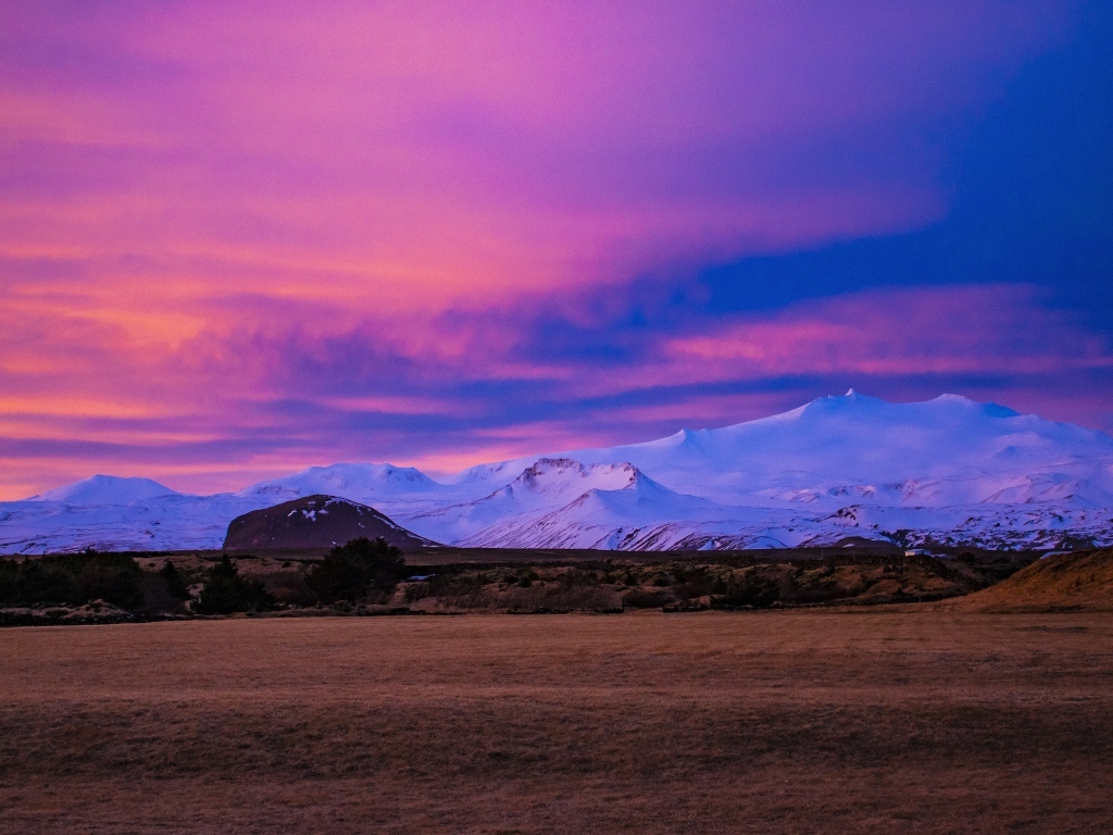 Покрытые белым снегом горы на фоне розового неба