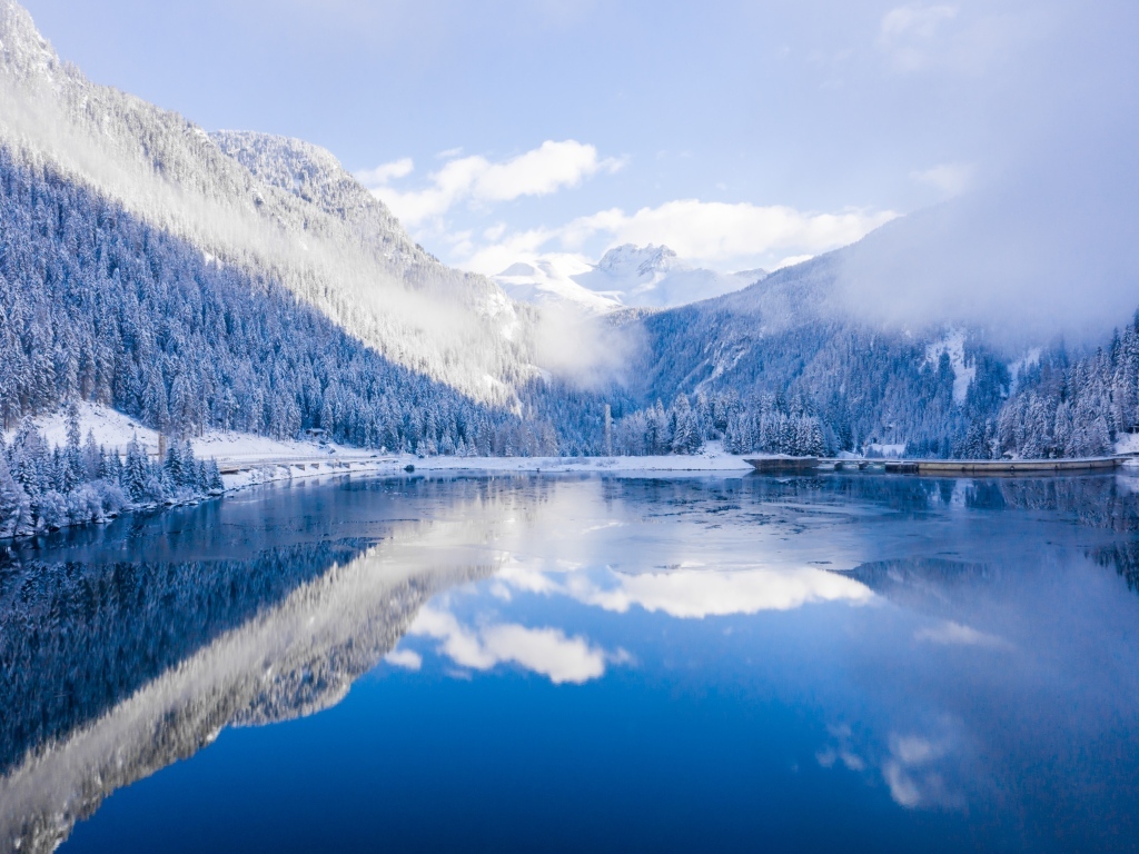 Покрытые снегом горы у покрытого льдом озера