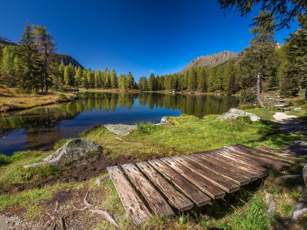 Мост на берегу озера в горах под голубым небом