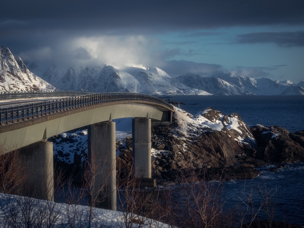 Мост через реку в заснеженных горах 
