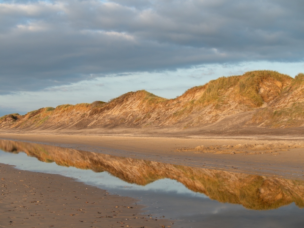 Холты отражаются в реке под грозовым небом