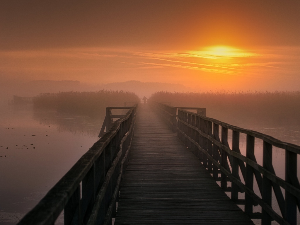 Деревянный мост над рекой на закате