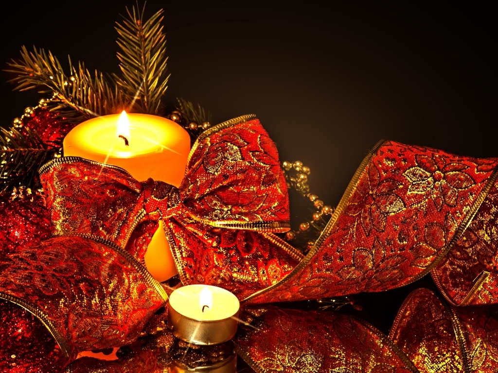 Зажженная свеча с красным бантом на черном фоне на Новый год