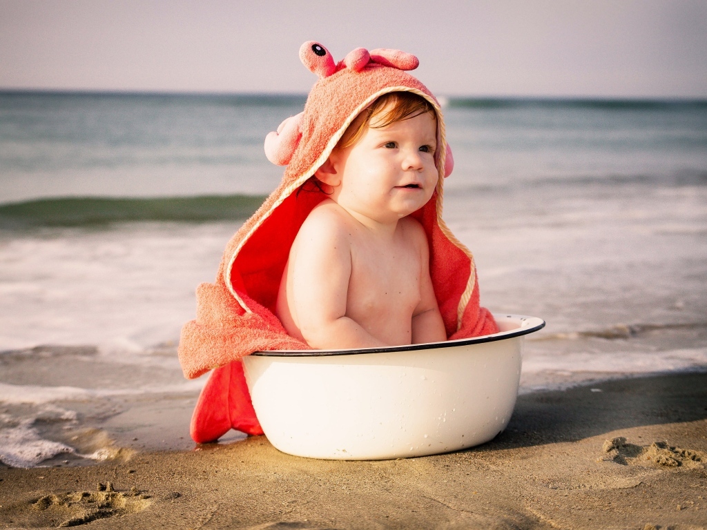 Ребенок в миске на берегу моря