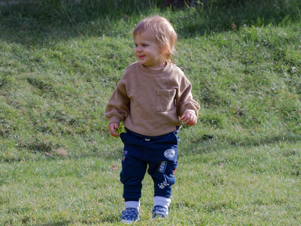 Веселый маленький мальчик гуляет на природе