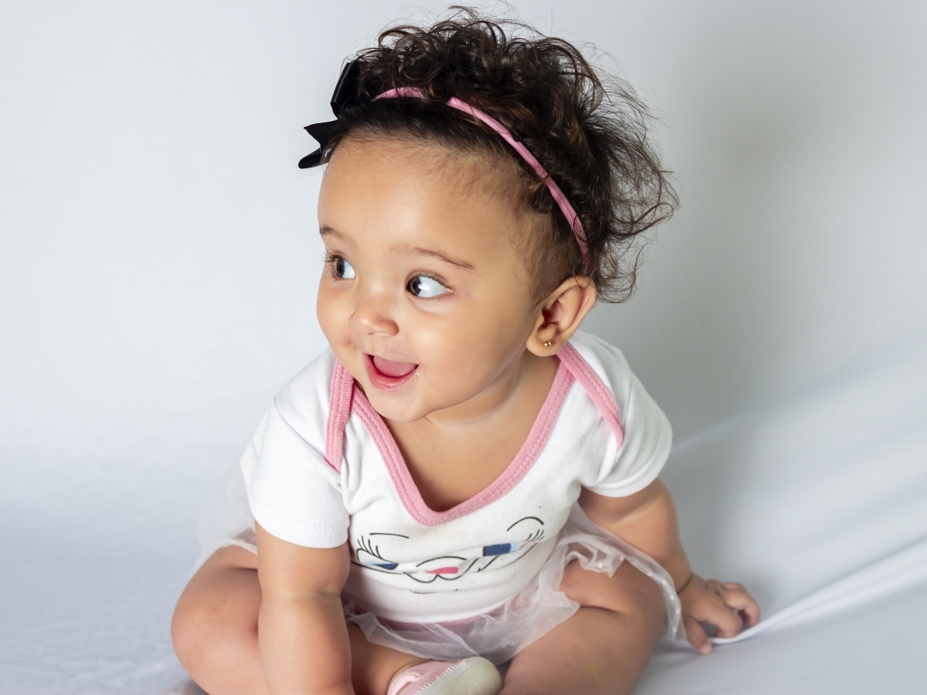 Веселая маленькая девочка с ободком на голове