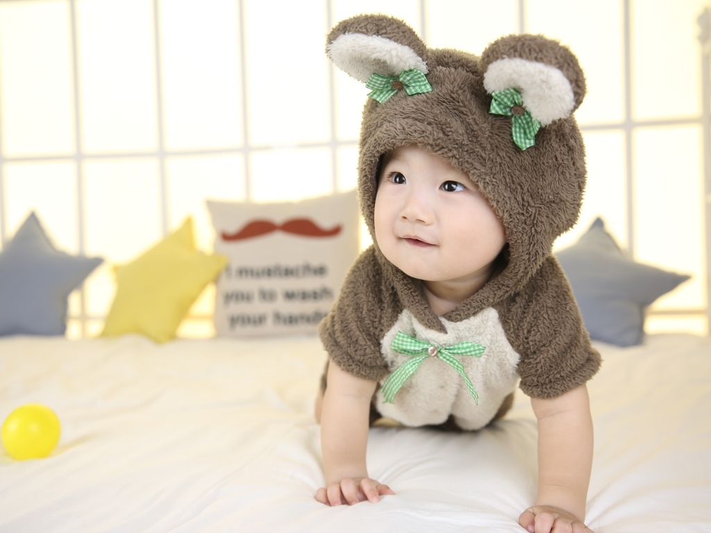 Ребенок в костюме медвежонка на кровати