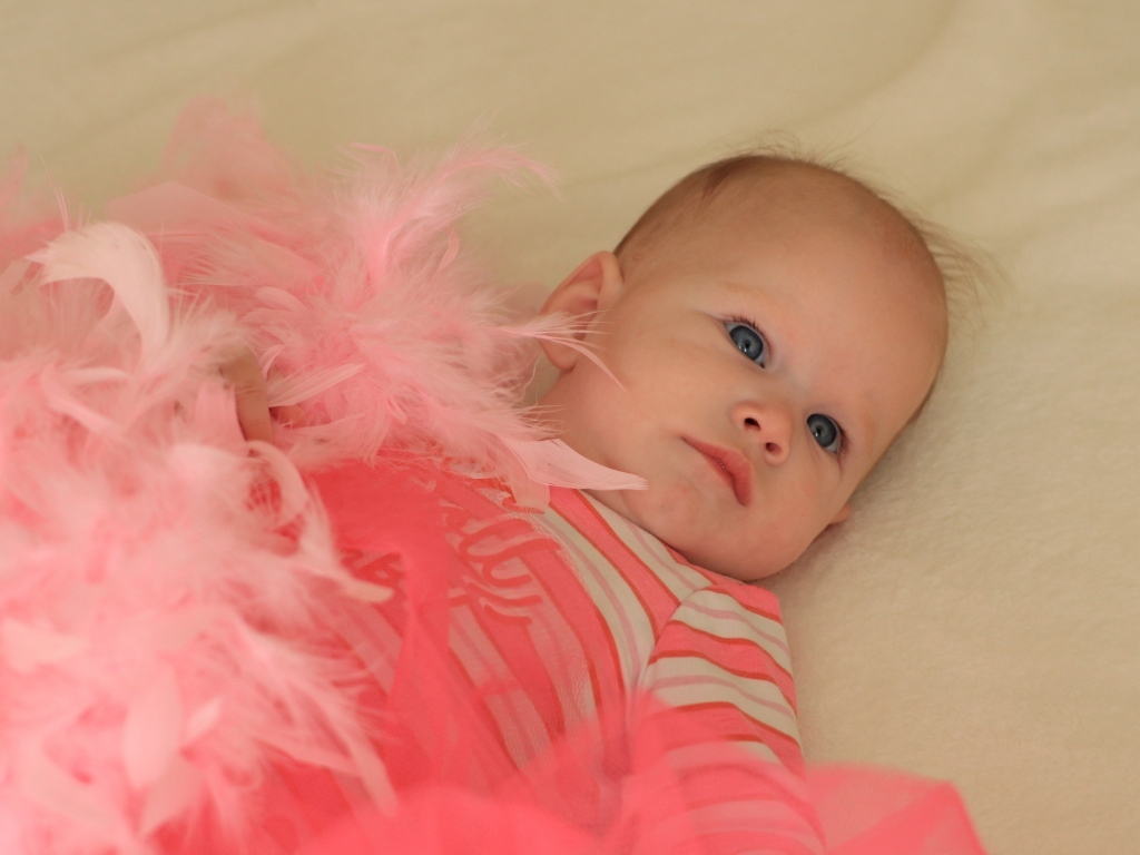 Милая малышка с розовыми перьями