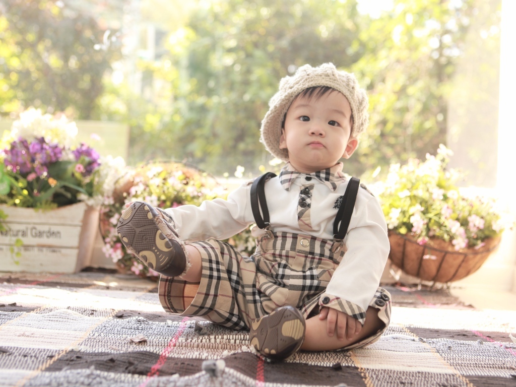 Смешной мальчик азиат у цветов