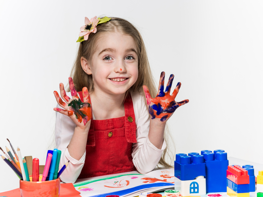 Маленькая девочка рисует красками