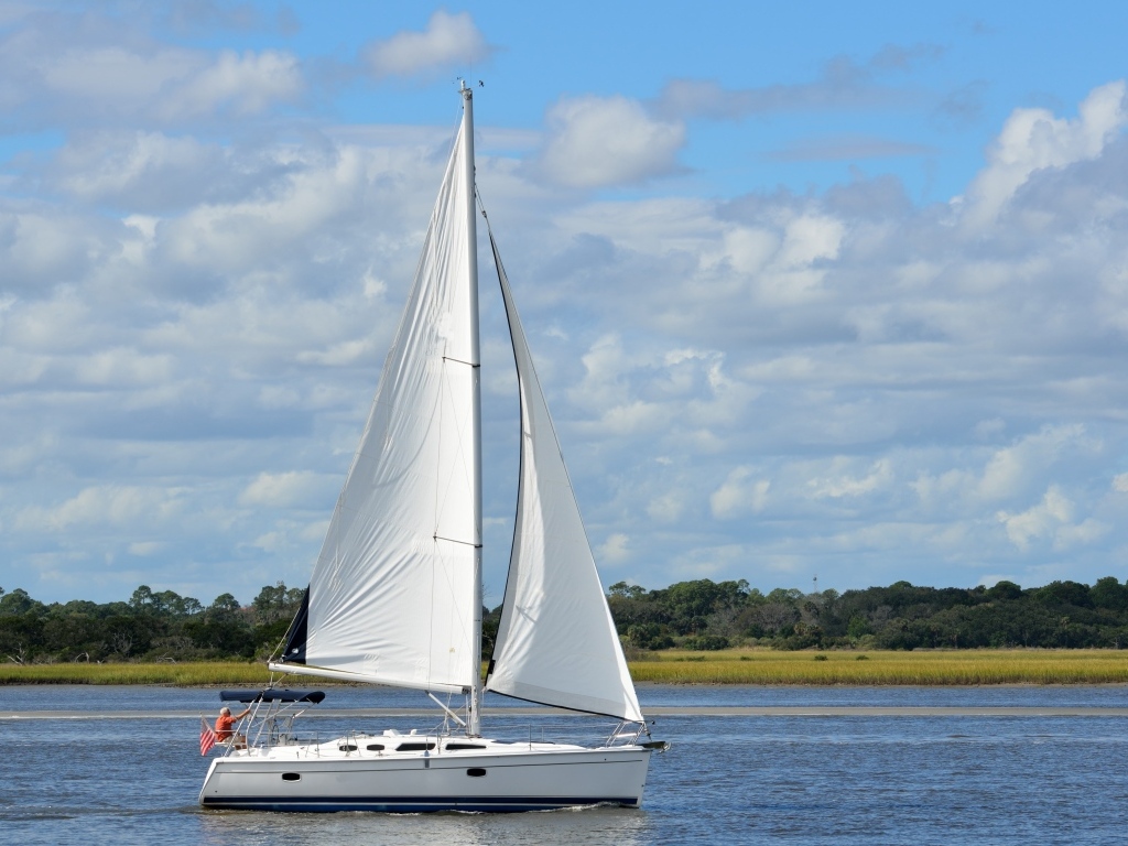 Яхта с белыми парусами на реке