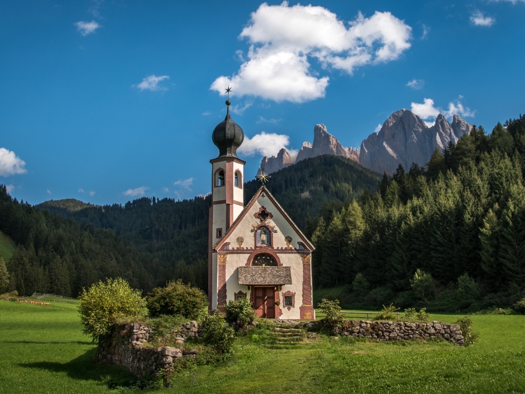 Старая церковь на фоне гор под красивым голубым небом, Италия