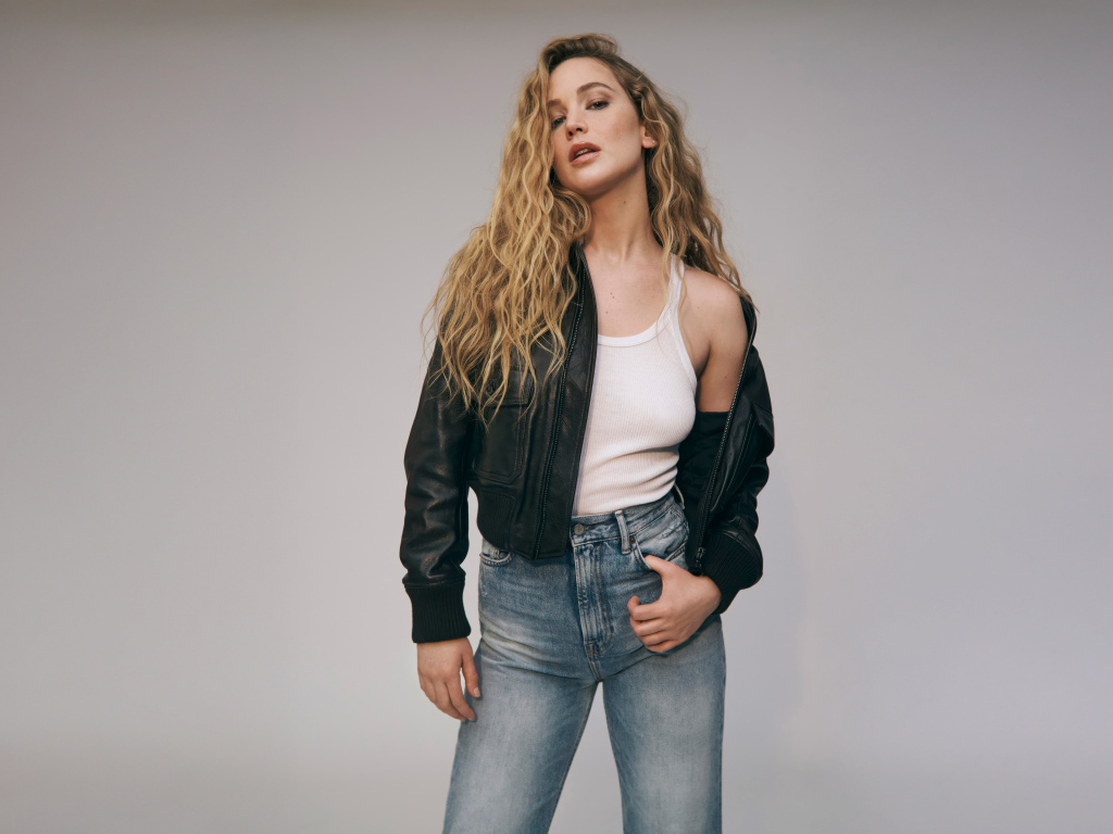 Американская актриса Дженнифер Лоуренс  в джинсах на сером фоне