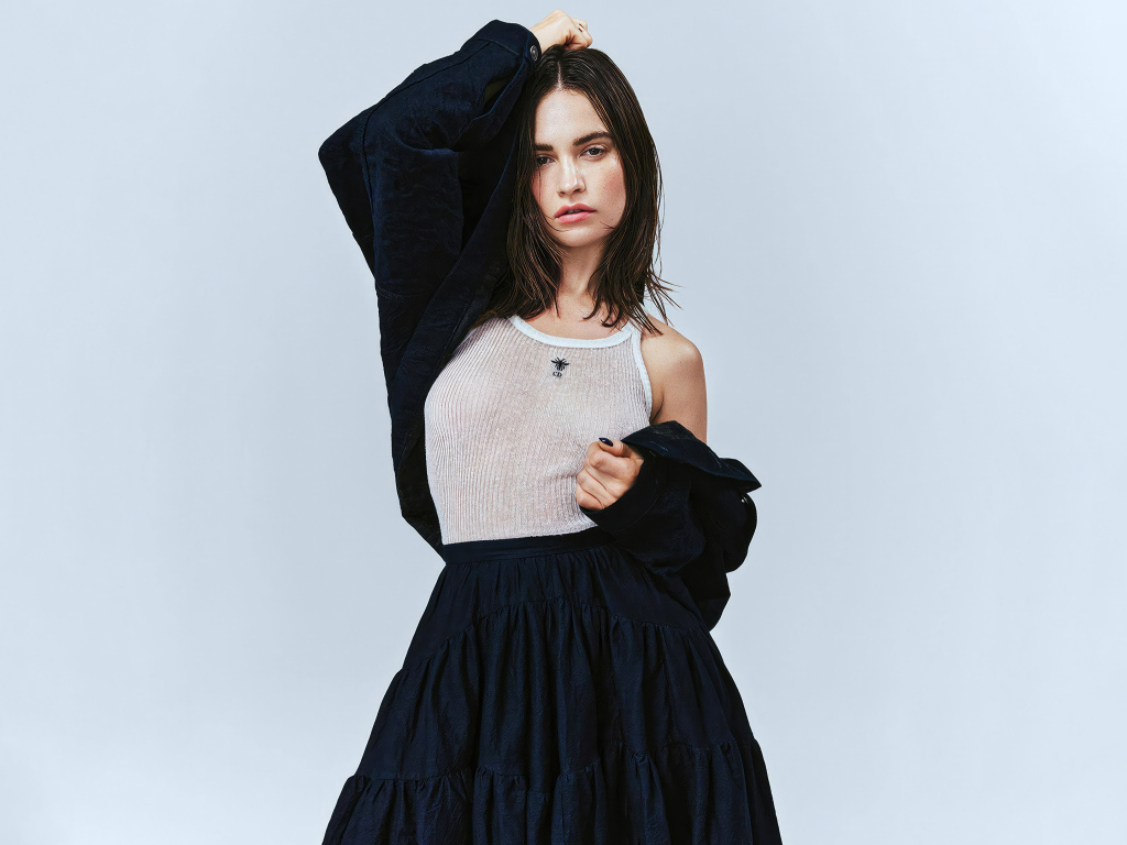 Красивая актриса Лили Джеймс стоит у стены