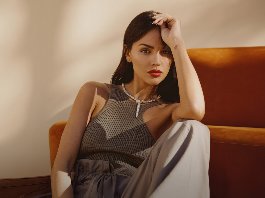 Красивая брюнетка, актриса Эйса Гонсалес сидит у дивана