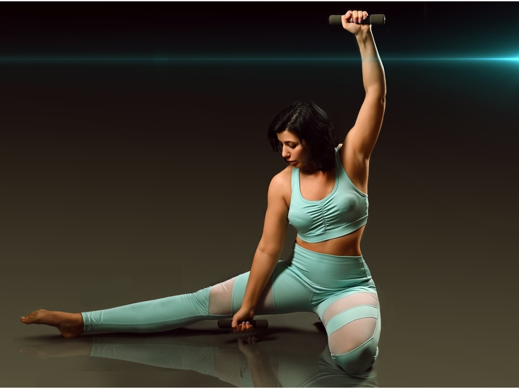Девушка занимается фитнесом с гантелями