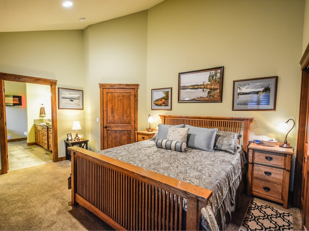 Большая деревянная двуспальная кровать в комнате