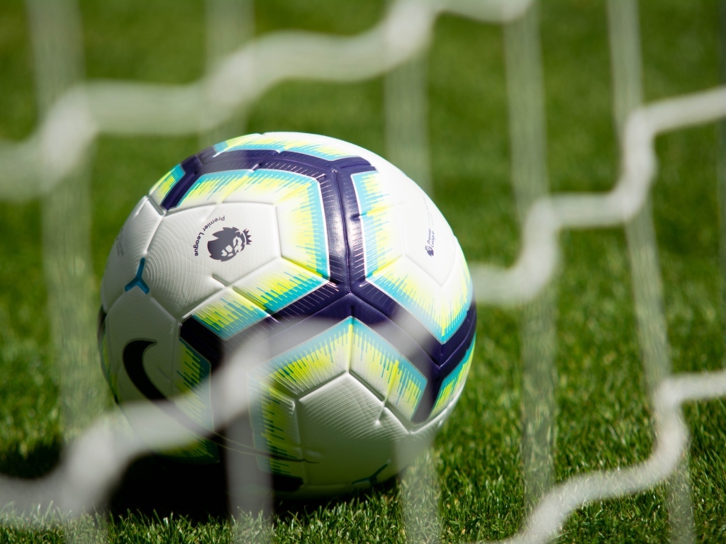 Футбольный мяч у сетки на поле