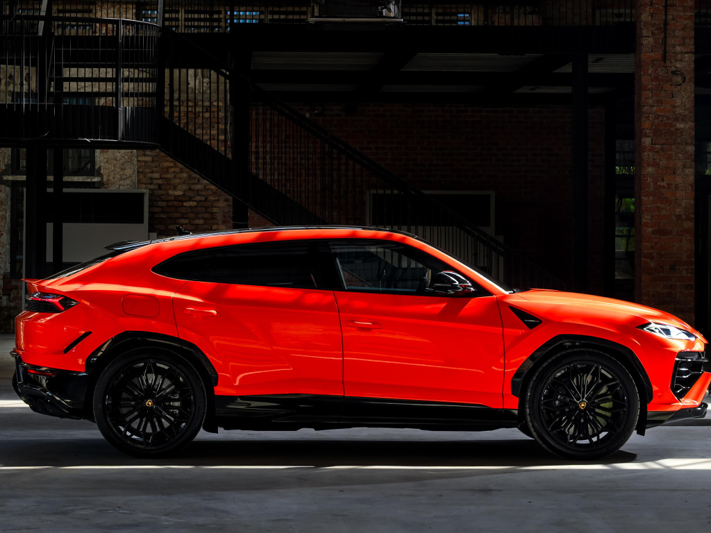 Вид сбоку на красный внедорожник Lamborghini Urus