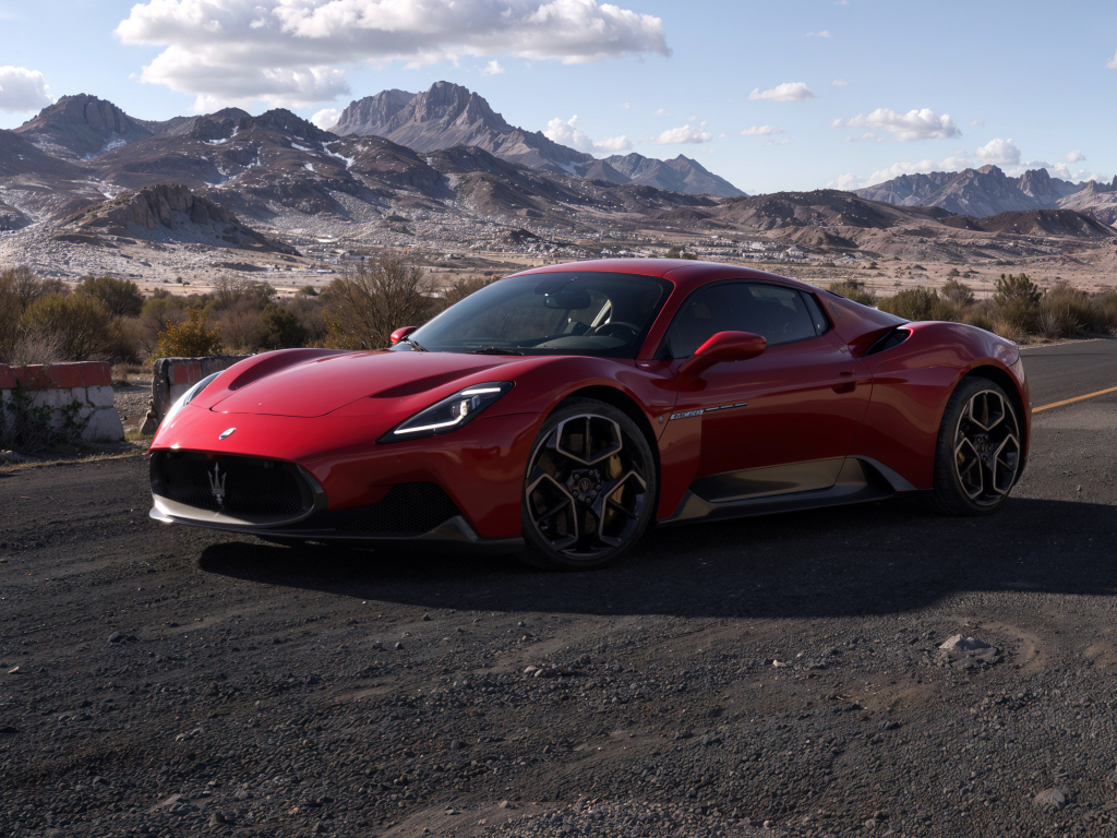 Красный автомобиль Maserati MC20 на фоне гор