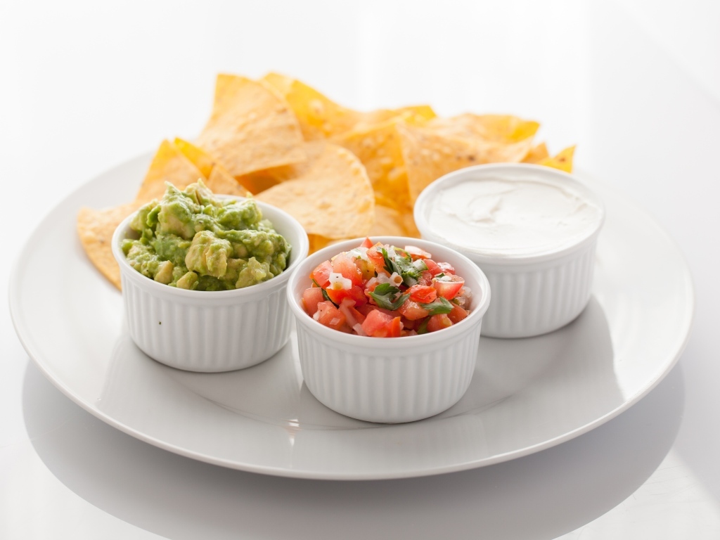 Чипсы с соусом на большой белой тарелке