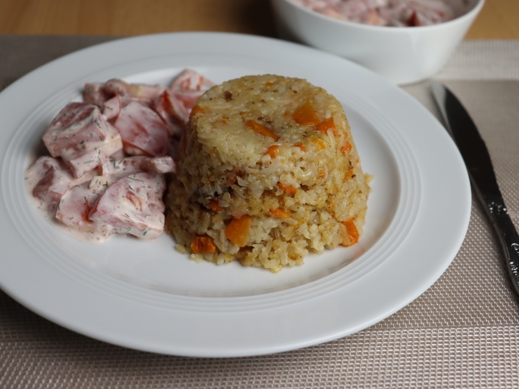 Рис с салатом на большой белой тарелке