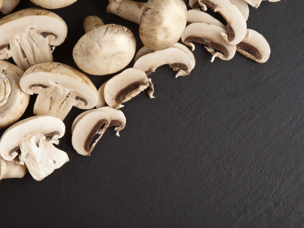 Нарезанные шампиньоны на сером столе