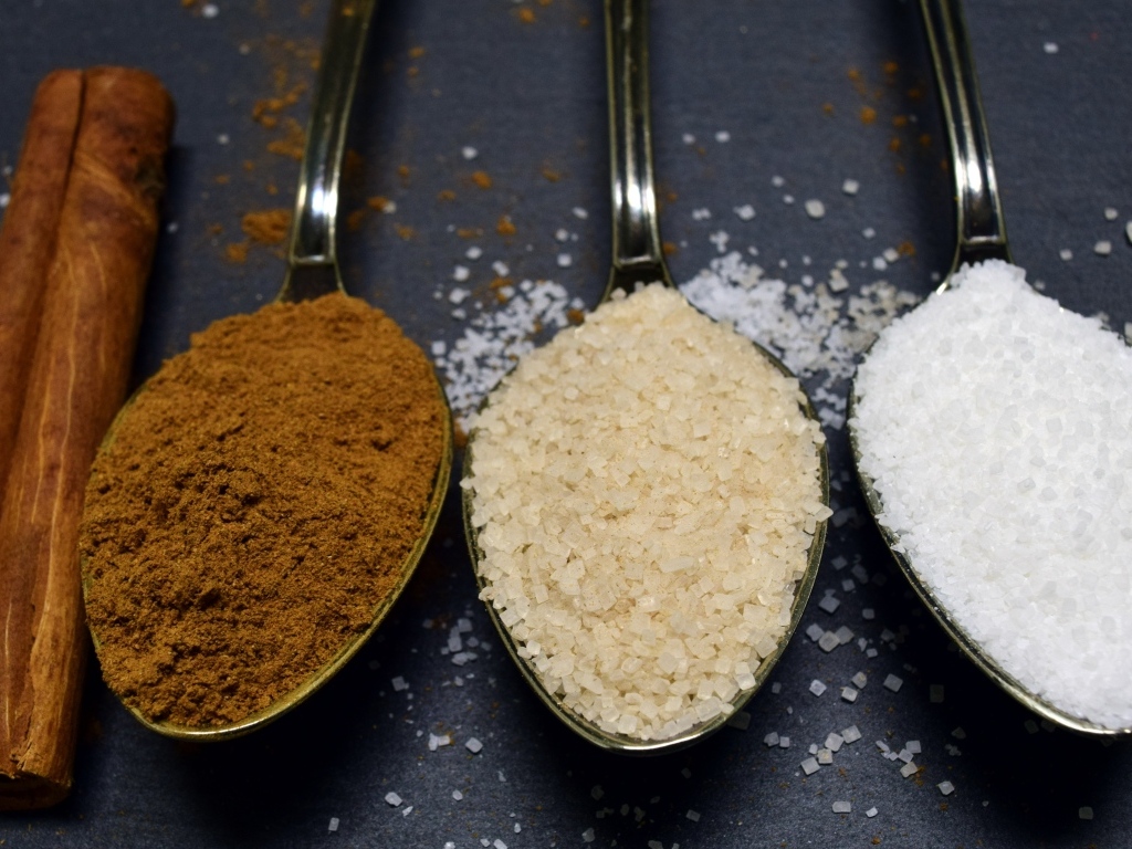 Три ложки со специями на сером столе