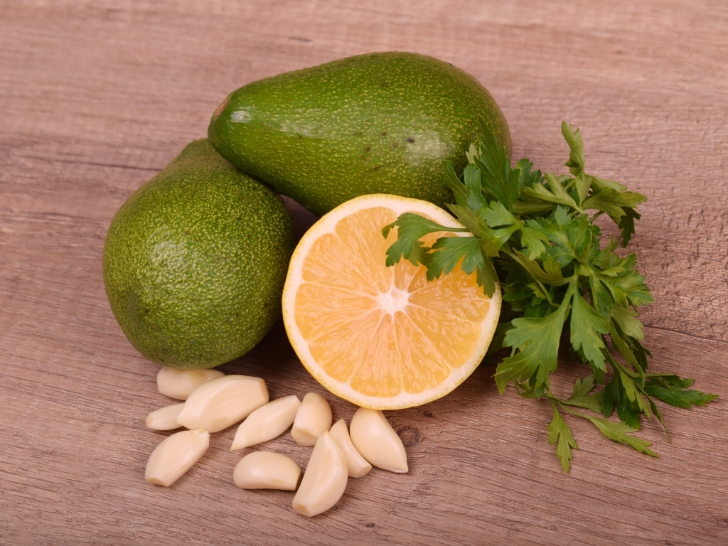 Авокадо на столе с чесноком и лимоном