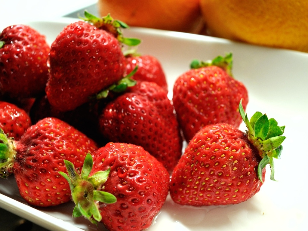 Ароматная красная клубника в белой тарелке