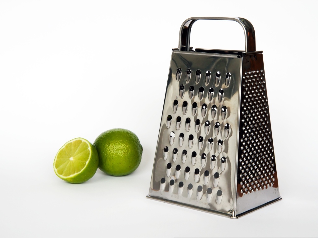 Терка с зеленым лаймом на сером фоне