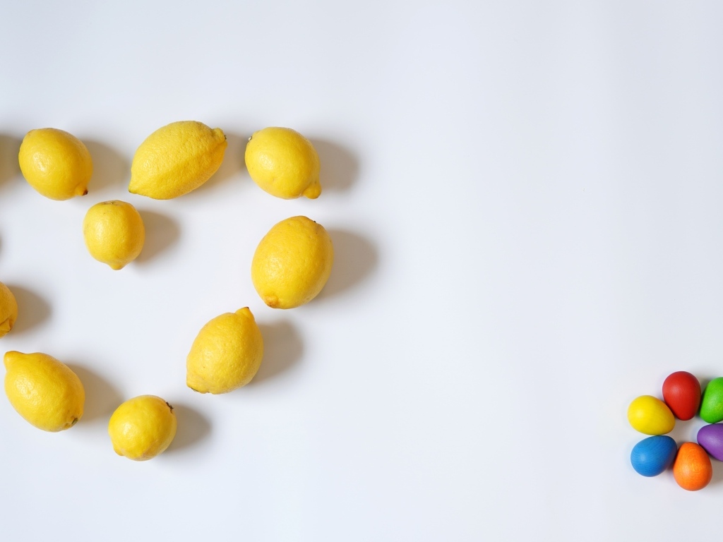 Сердце из желтых лимонов на сером фоне с конфетами