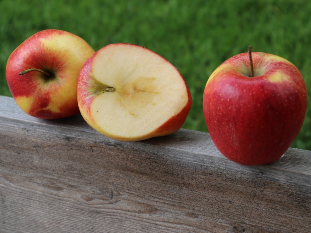 Красные яблоки лежат на деревянной доске