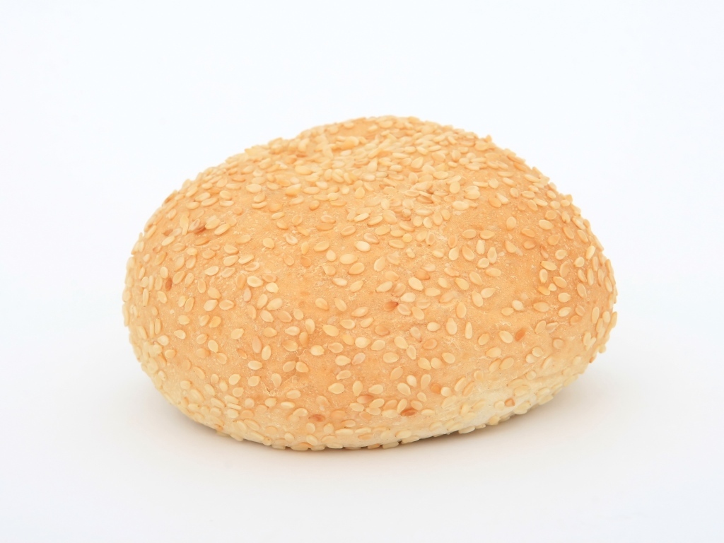 Булочка с кунжутом на белом фоне