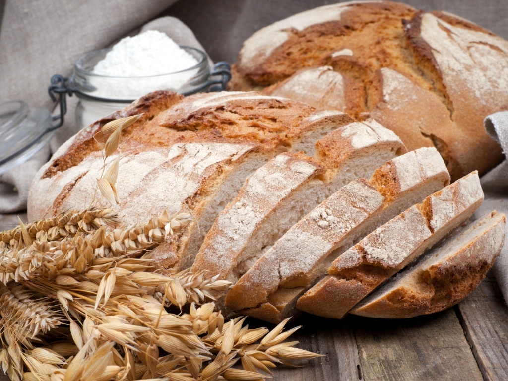 Нарезанный ржаной хлеб с колосьями на столе