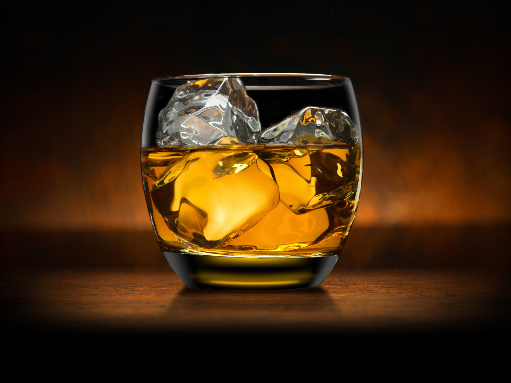 Стакан виски со льдом на столе