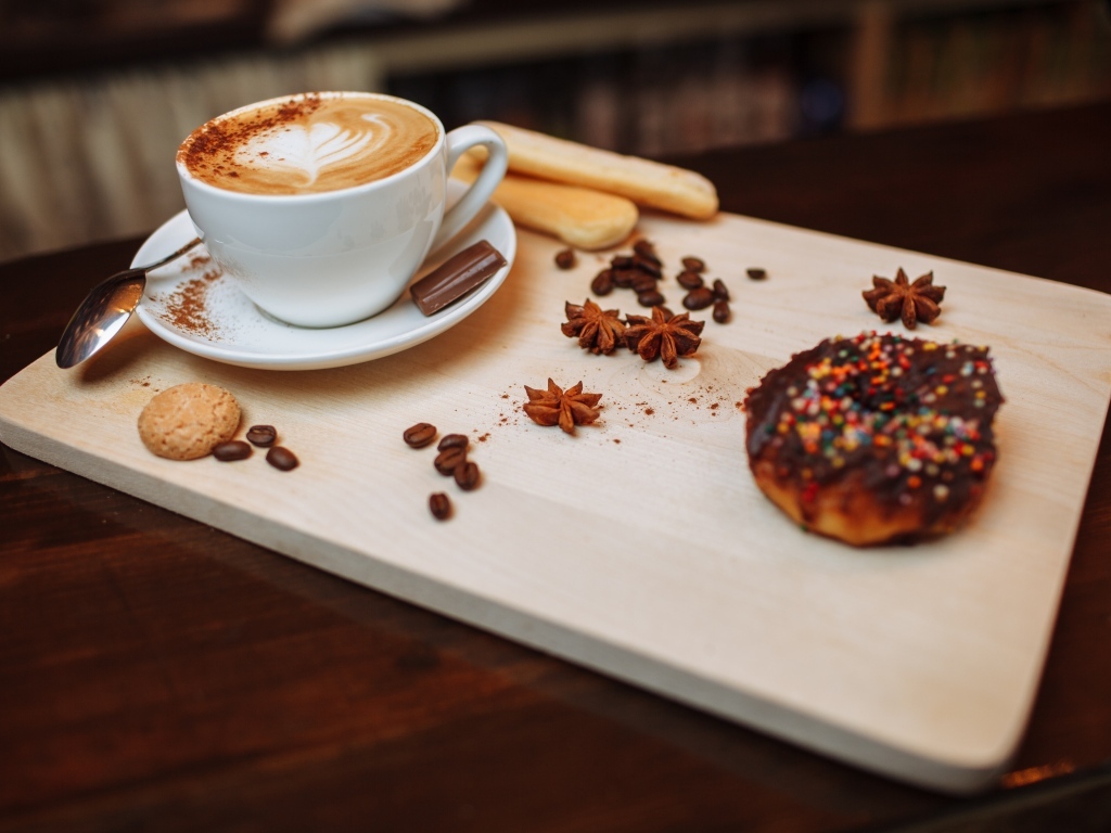 Чашка кофе на доске со специями и печеньем