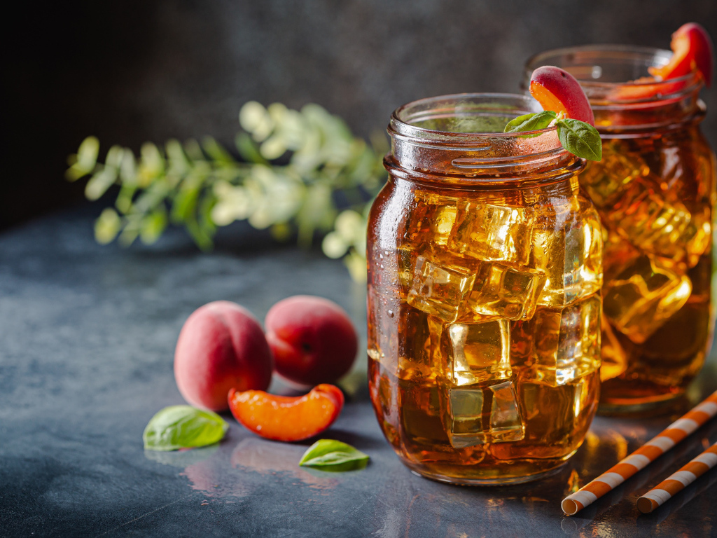 Холодный чай со льдом на столе с абрикосами