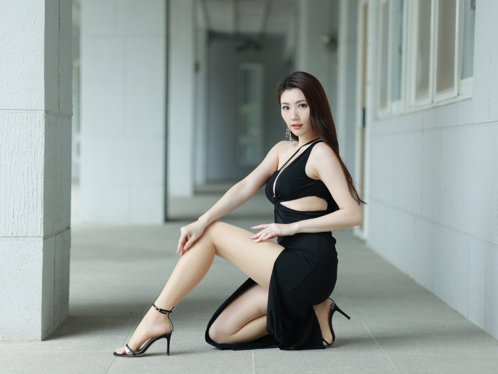 Девушка азиатка в черном наряде позирует для фото