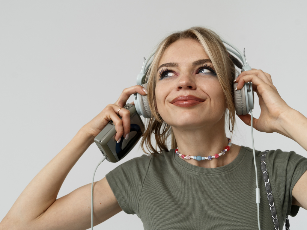 Красивая девушка в наушниках с плеером