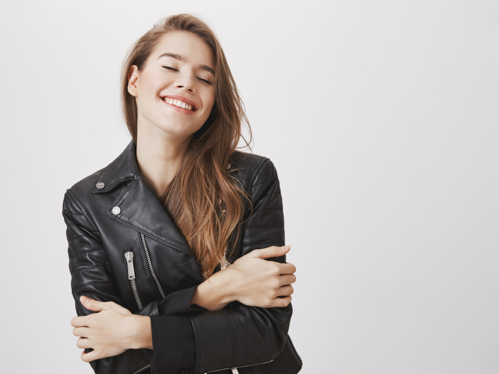 Девушка в черной кожаной куртке с закрытыми глазами