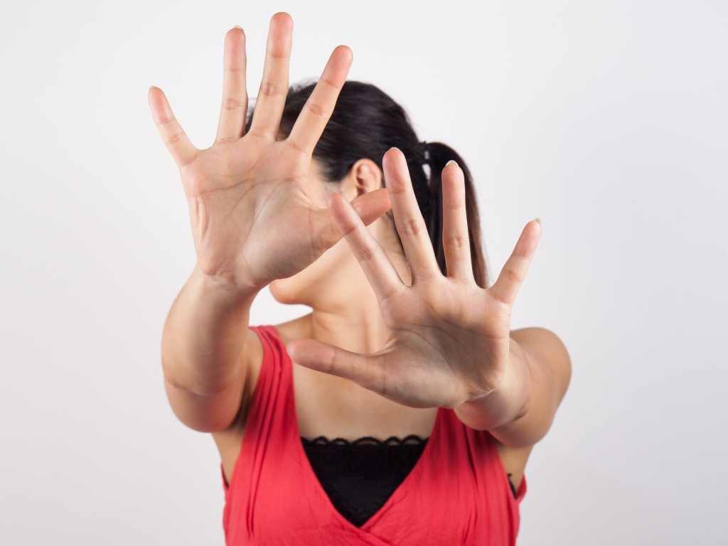 Девушка закрывает лицо руками