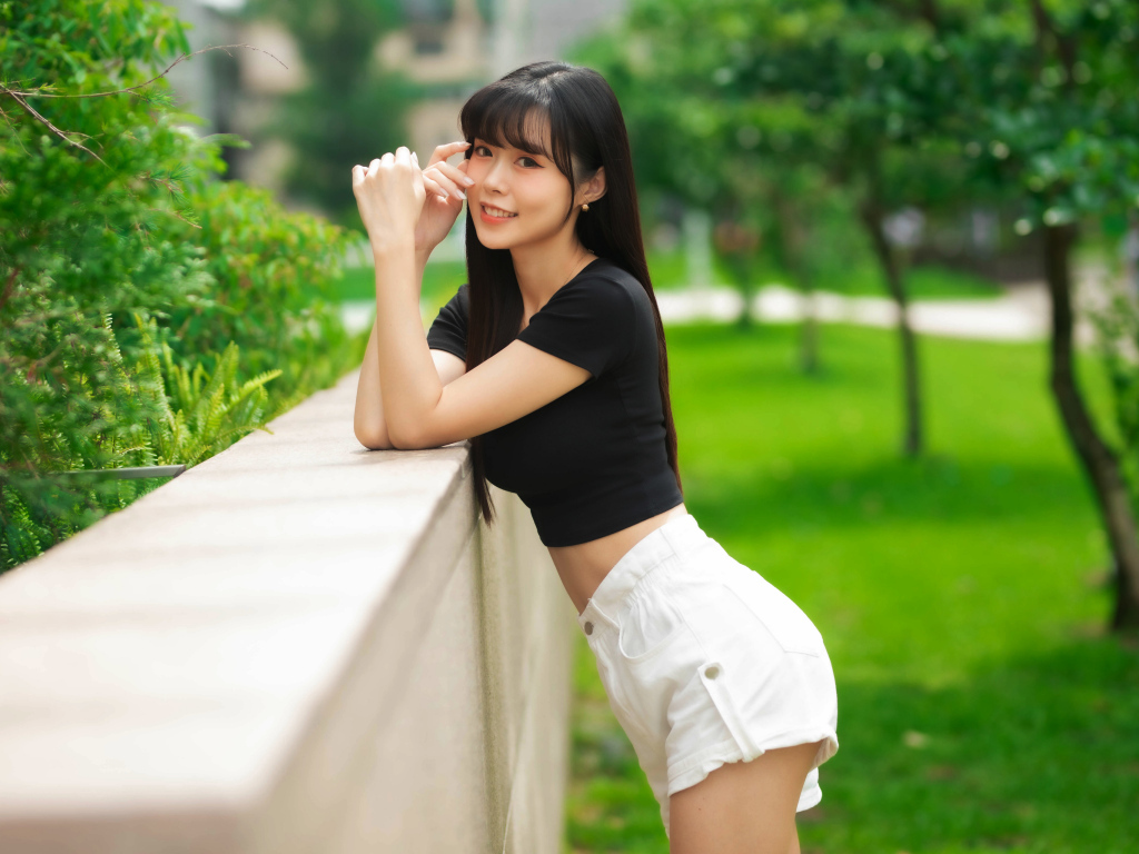 Молодая азиатка в белых шортах и футболке